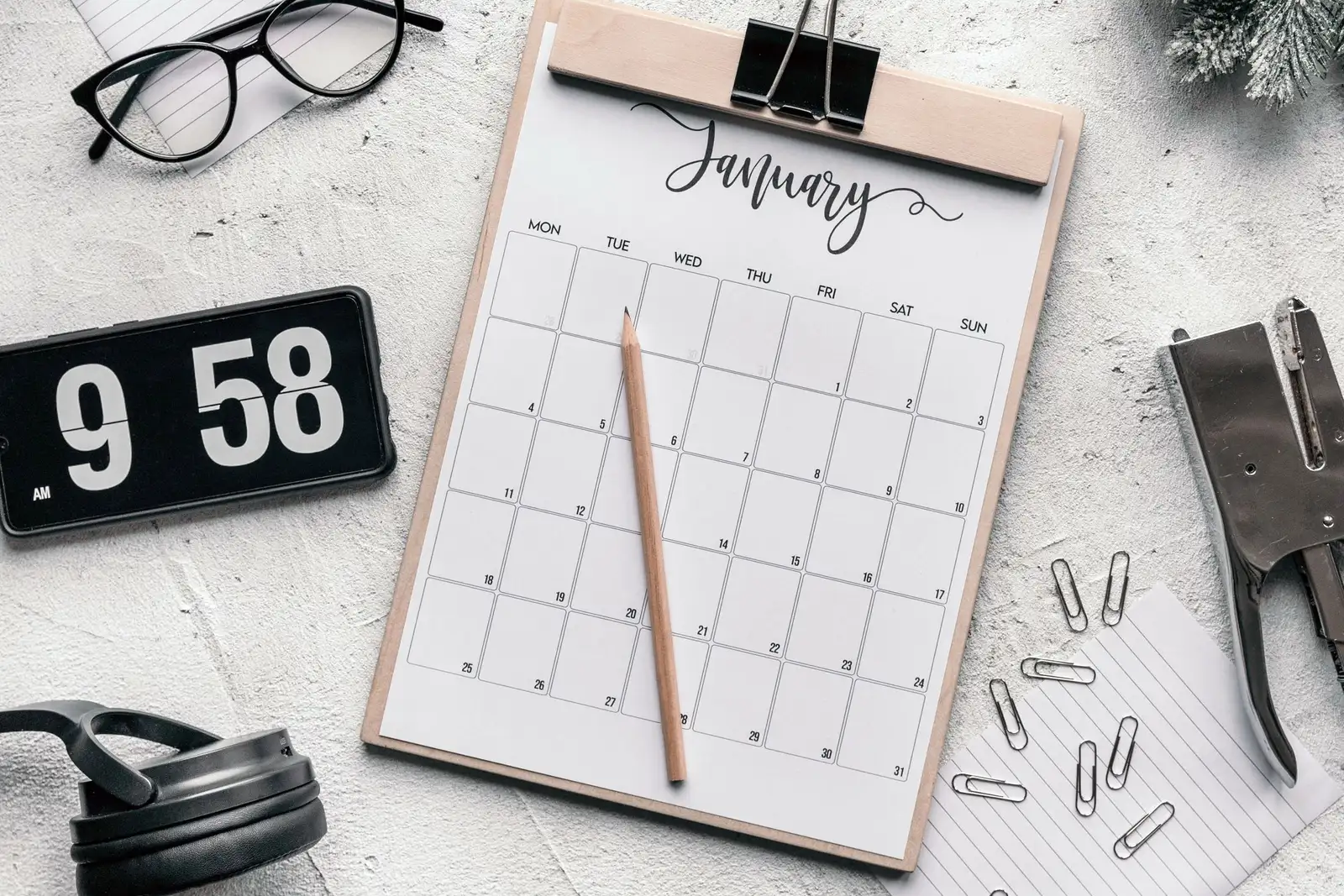 Calendar, digital clock ও stationery দিয়ে সাজানো planning desk