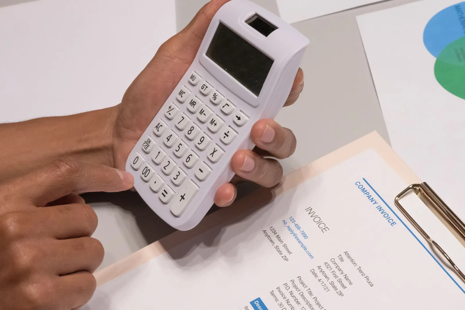 Invoice-এর পাশে হাতে calculator নিয়ে হিসাব পরীক্ষা করা হচ্ছে