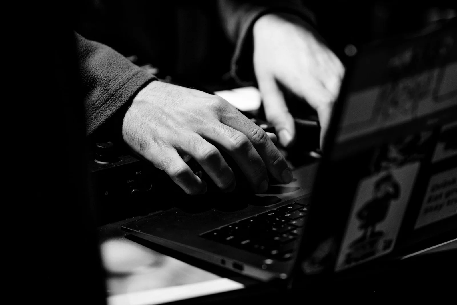 সাদা-কালো ছবিতে laptop keyboard-এ typing করছেন একজন ব্যক্তি