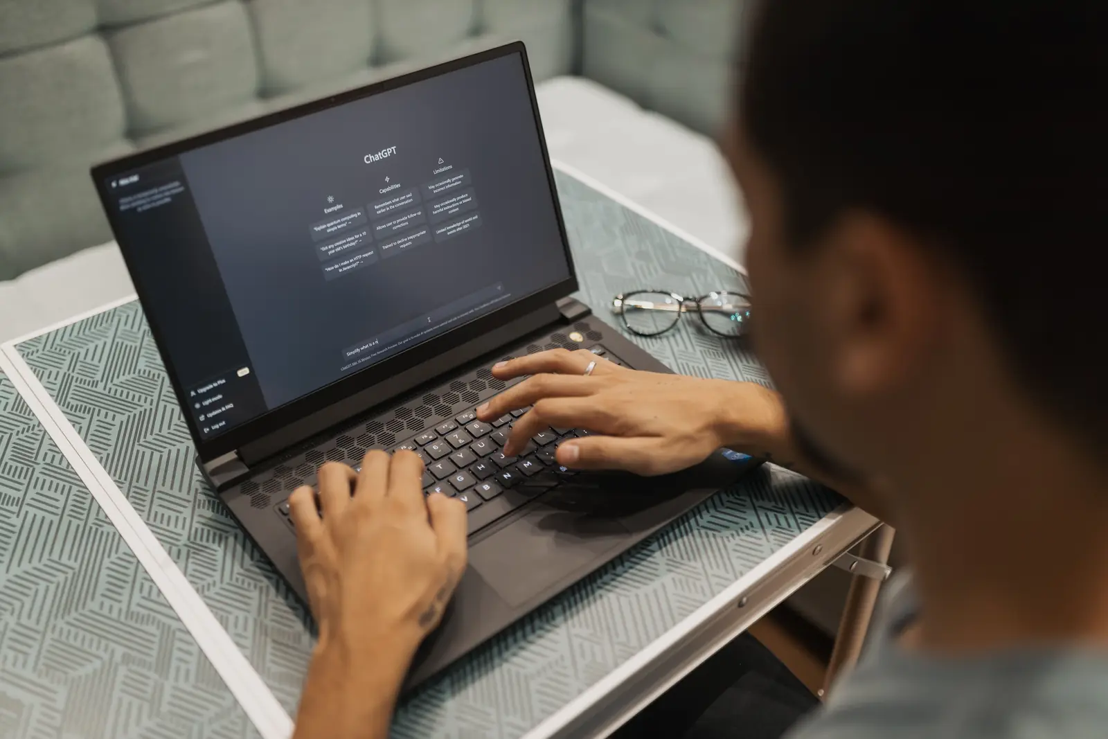 Laptop-এ AI assistant ব্যবহার করে উত্তর যাচাই করছেন একজন ব্যক্তি