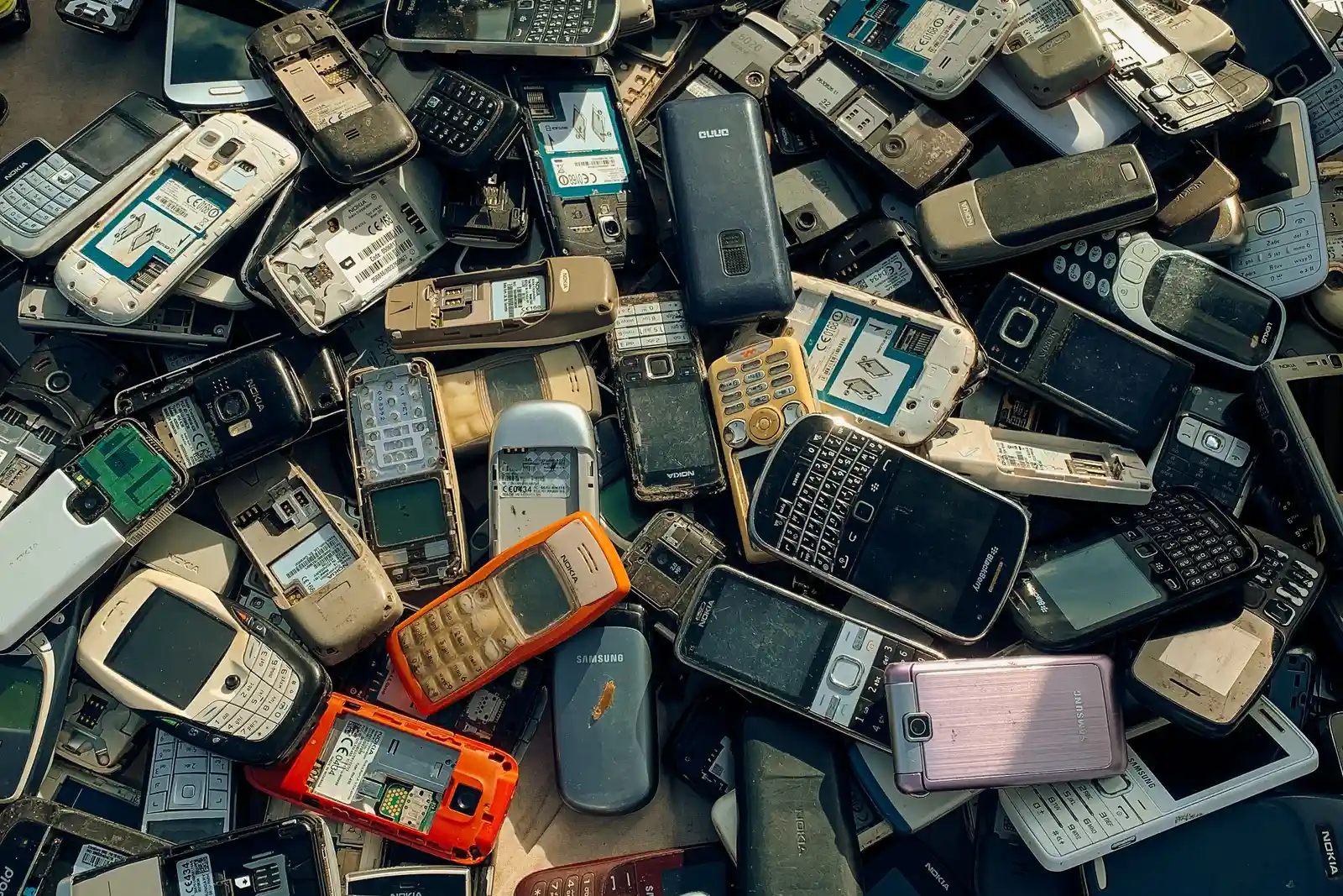 Recycle বা resale-এর আগে data wipe করার জন্য রাখা কয়েকটি পুরোনো smartphone-এর স্তূপ