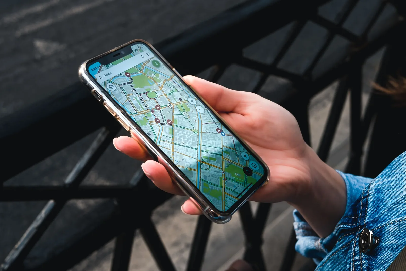বাইরে হাতে ধরা smartphone-এর screen-এ রাস্তার map দেখা যাচ্ছে